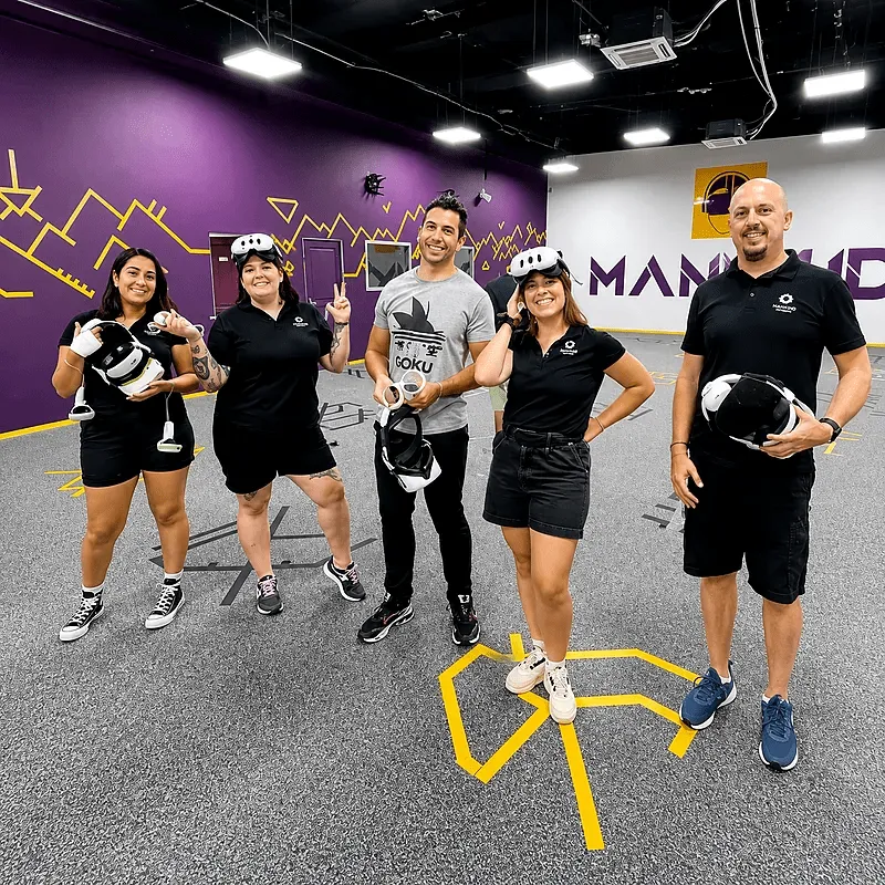 Équipe en team building réalité virtuelle posant dans l’arène Mankind à Metz, casques VR à la main