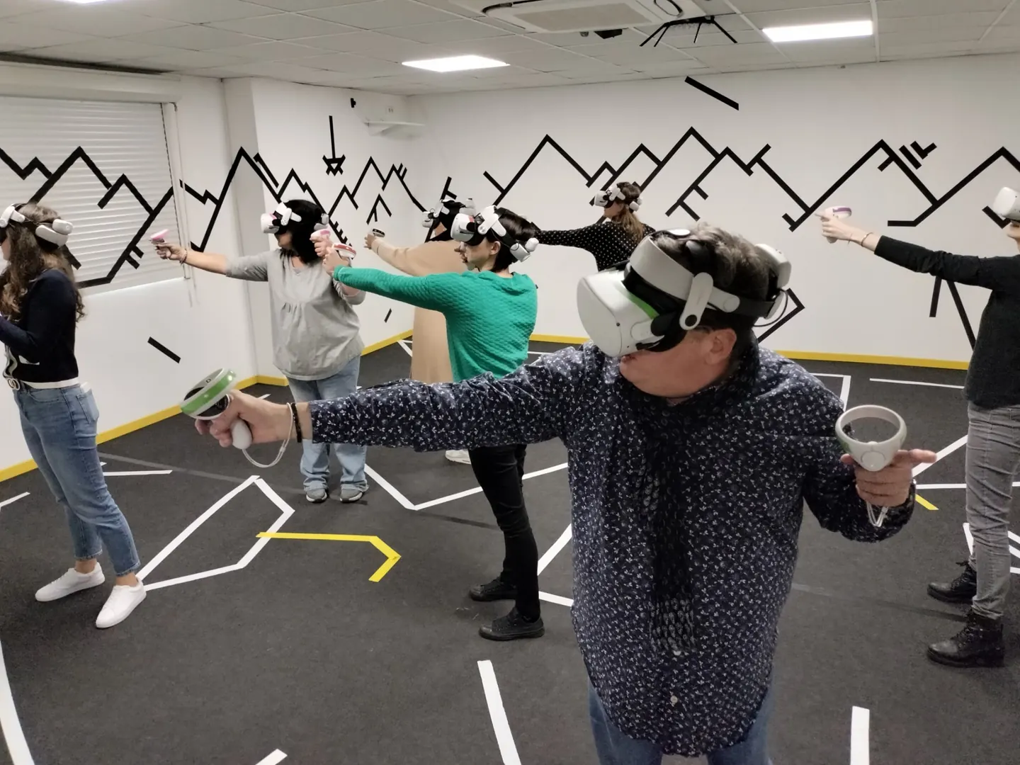 Collègues en casque de réalité virtuelle, bras tendus, pendant un team building en Hyper-immersion chez Mankind à Metz